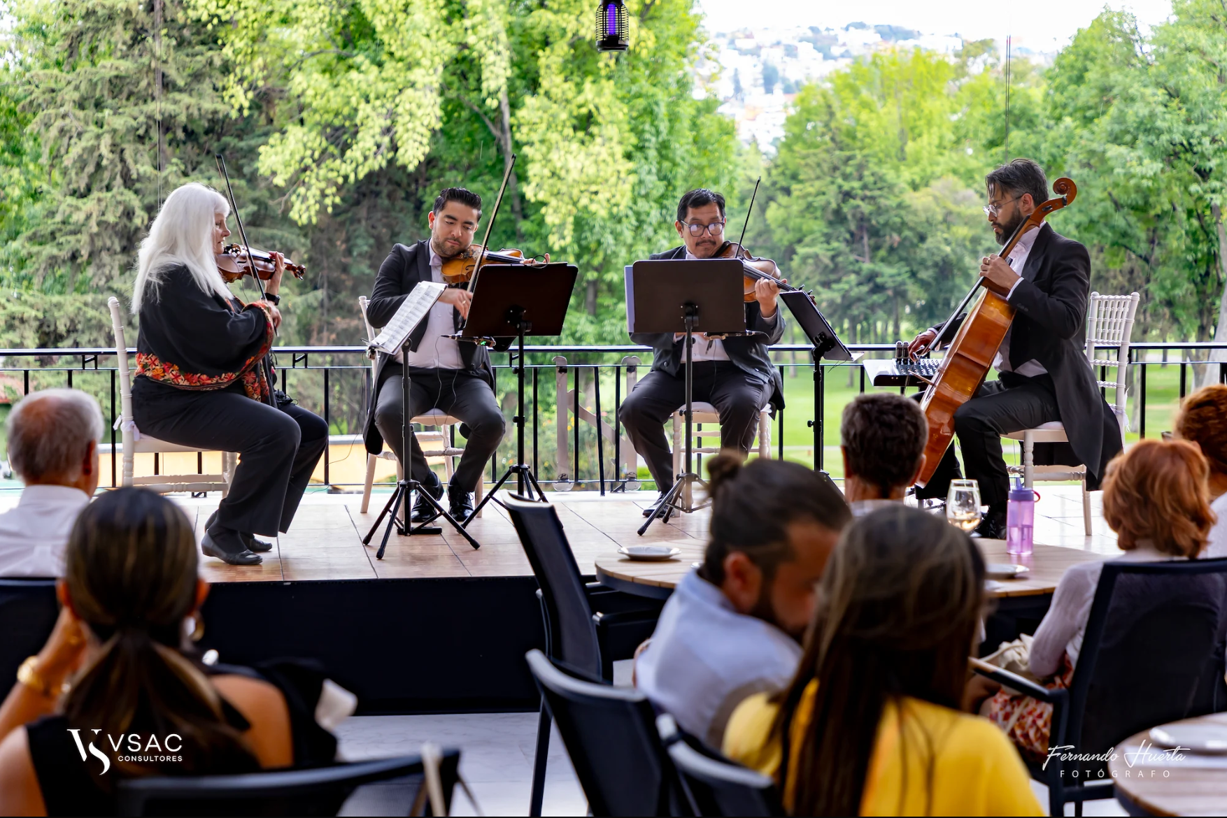 Cuarteto Ars Musik interpretando ante el público en una terraza con jardín al fondo